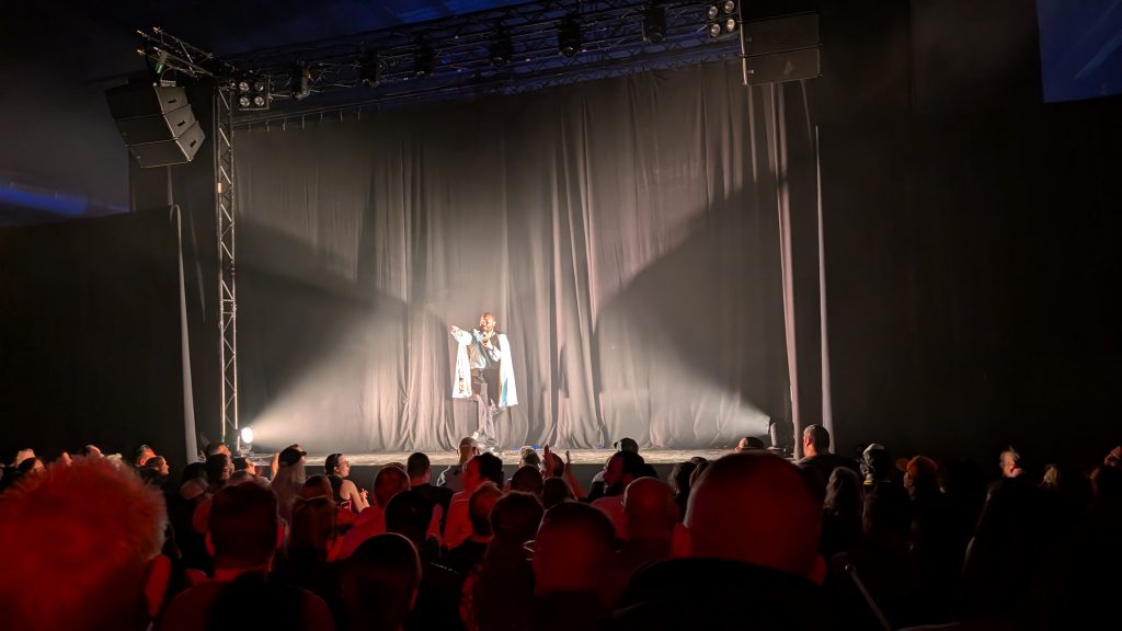 Lando on a stage talking to hundreds of people